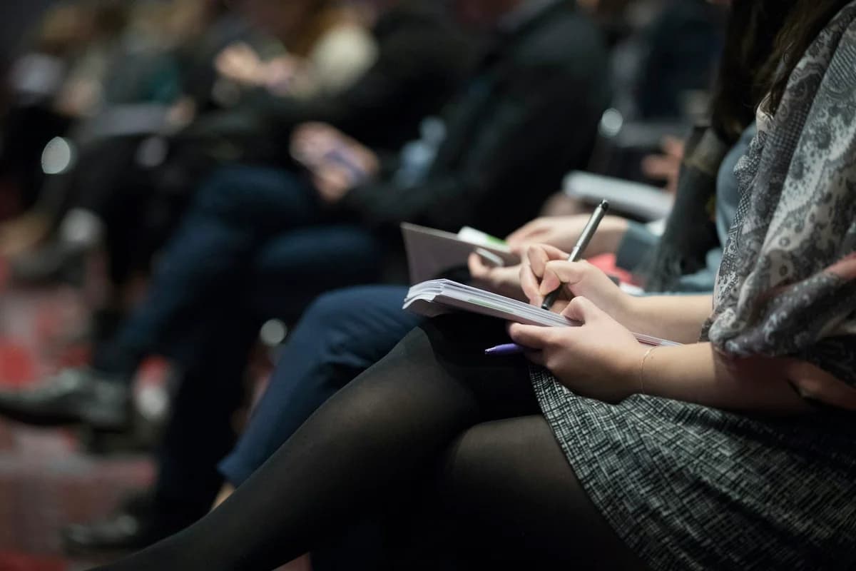 Delegates taking notes during a healthcare conference session.