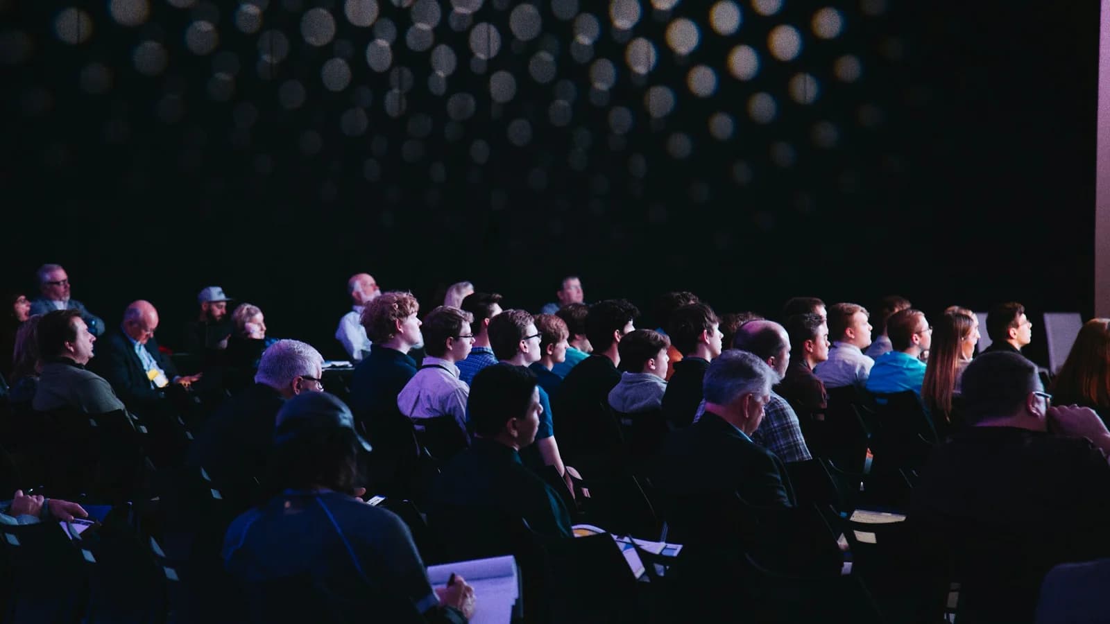 Audience seated in a modern auditorium during a healthcare conference session.