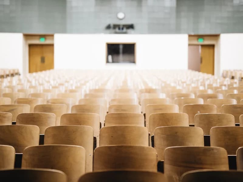 Empty wooden seats in a modern medical education auditorium.