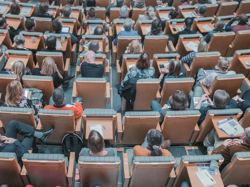 Delegates seated in a tiered auditorium during a clinical investigator meeting.