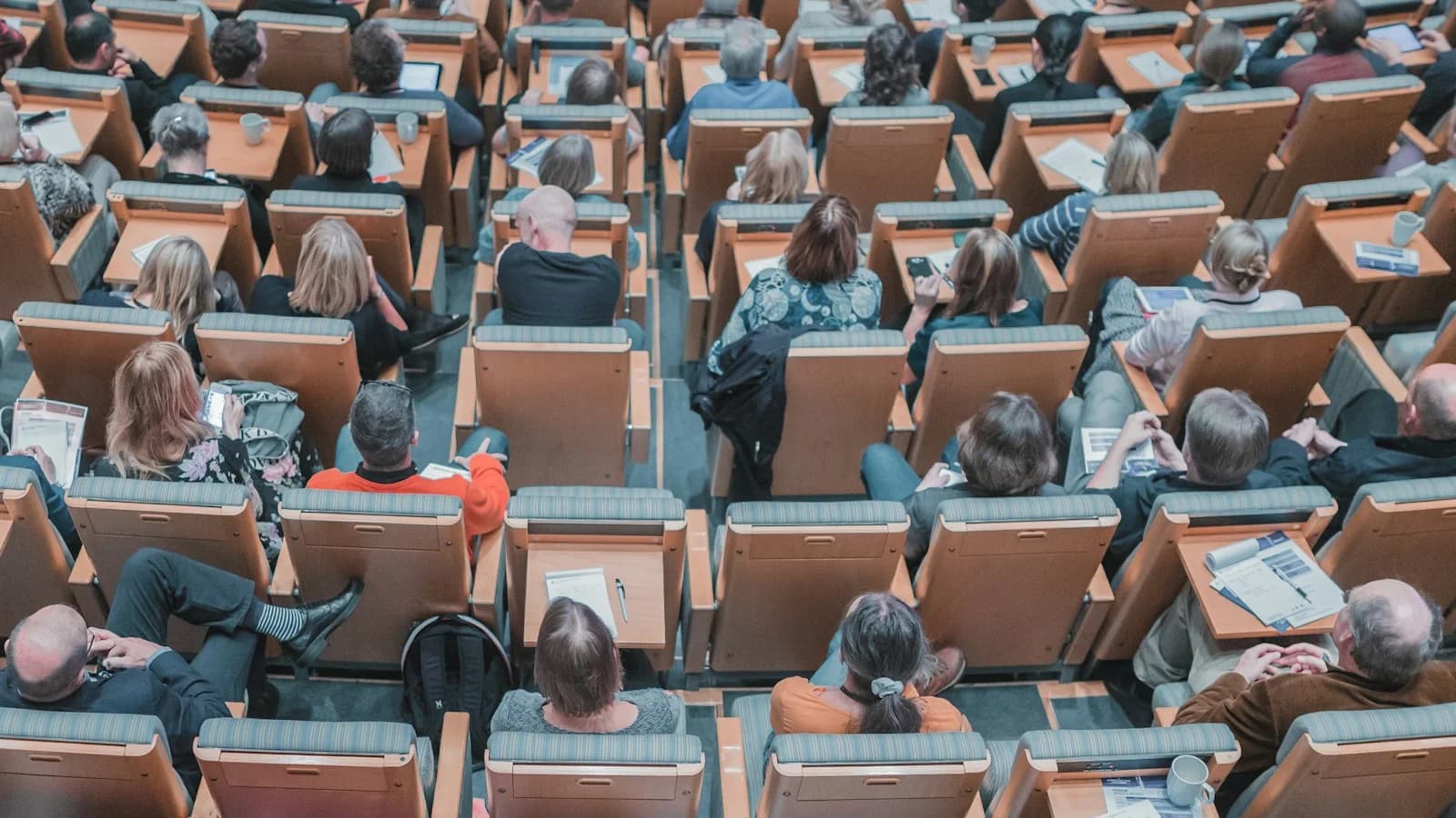 Delegates seated in a tiered auditorium during a clinical investigator meeting.